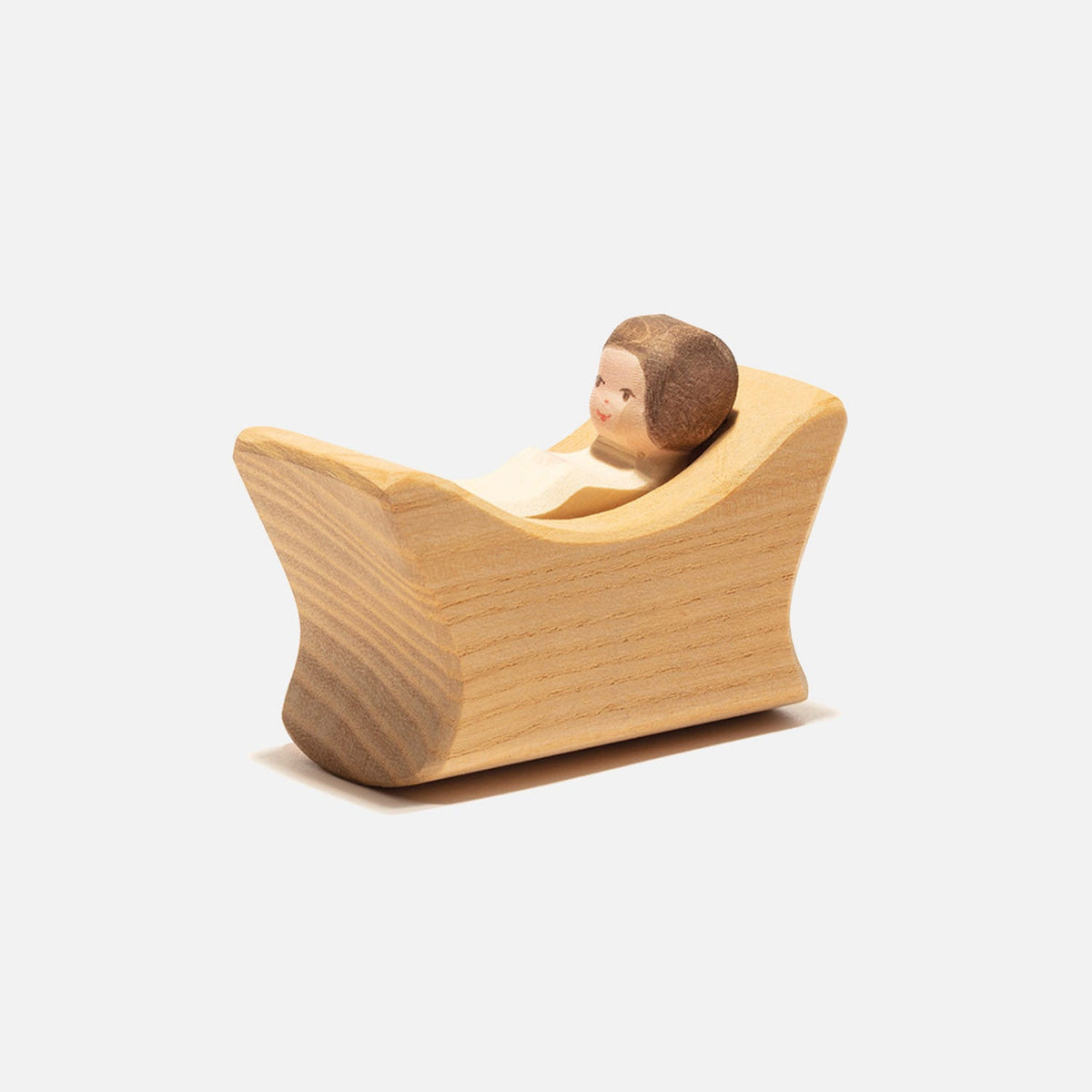 Handgefertigtes Holzkind im Wiegenbett